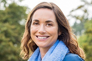 Woman smiling outdoors after smile makeover