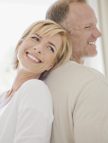 Senior man and woman smiling after full mouth reconstruction