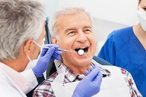 Senior man receiving dental treatment before dental implant denture placement