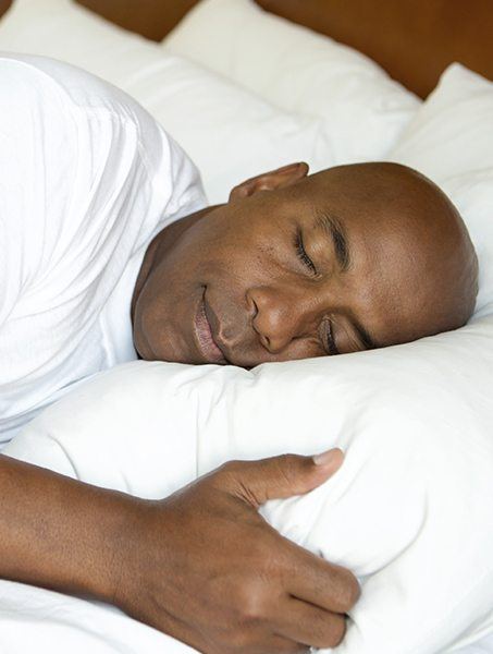 Man with nightguard for bruxism sleeping soundly