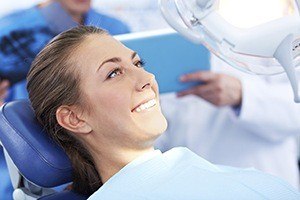 Happy smiling woman in dental chair for scaling and root planing