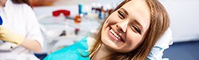 Smiling woman in dental chair for preventive dentistry