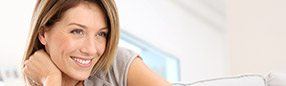 Woman with whole healthy smile after dental implant tooth replacement