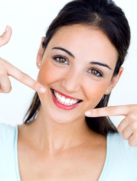 woman pointing to her smile after teeth whitening in West Monroe, LA