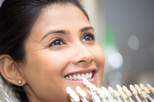 a dentist color matching a patient’s teeth