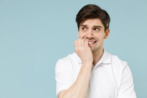 Anxious man chewing on his fingernails.